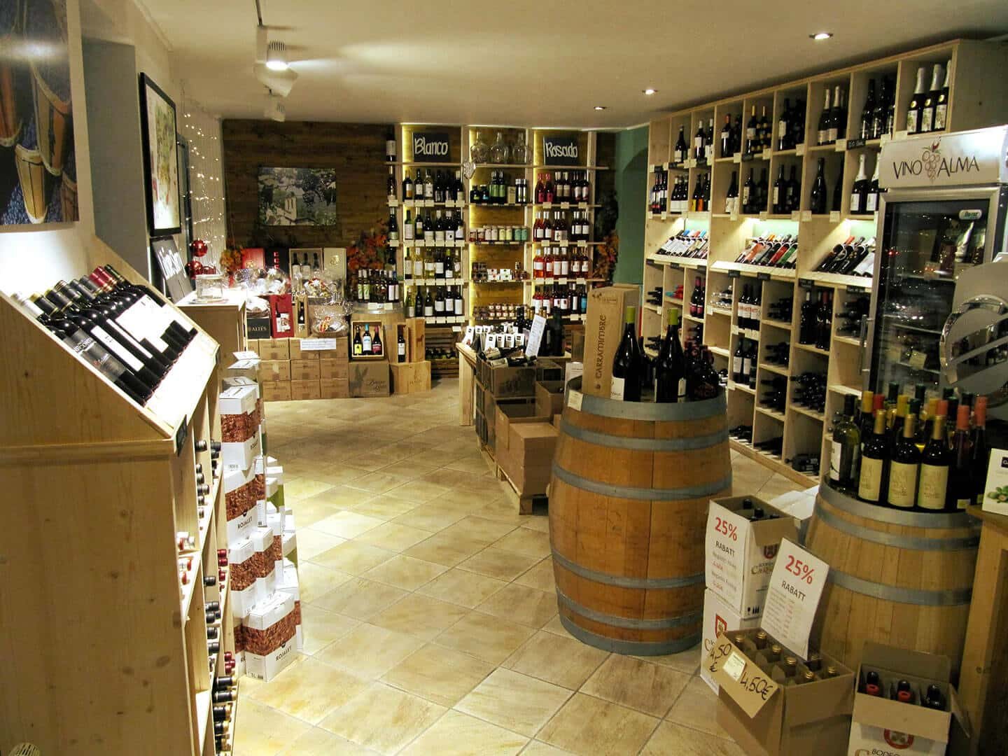 Innenansicht des Weinladens Vino&Alma in Dresden mit Weinregalen und Fässern